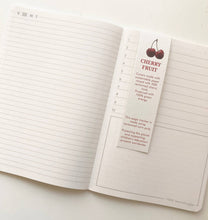 Load image into Gallery viewer, Notebook with a cherry-themed bookmark on a white background