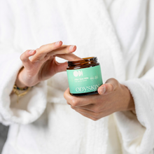 Load image into Gallery viewer, Person holding a jar of ODYSKIN cream against a white background