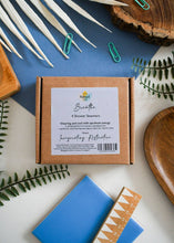 Load image into Gallery viewer, Box of 'Breathe' shower steamers with a blue background and decorative elements.