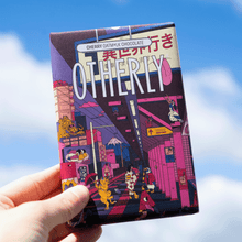 Load image into Gallery viewer, Chocolate bar with colorful packaging featuring a cityscape design held against a blue sky.