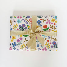 Load image into Gallery viewer, Gift box with floral pattern and gold ribbon on a white background