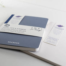 Load image into Gallery viewer, Blue notebook with white label on a light gray surface