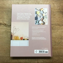 Load image into Gallery viewer, Back cover of a book with text and images on a wooden surface