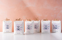 Load image into Gallery viewer, Four 'Shell on Earth' packages with floral designs on a pink background