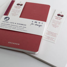 Load image into Gallery viewer, Red notebook with 'SUCCEED' branding and a Cherry Fruit label on a white background