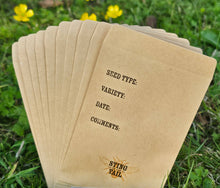 Load image into Gallery viewer, Stack of brown seed packets with text on a grassy background
