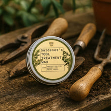 Load image into Gallery viewer, Gardener's Tool Treatment Wax container surrounded by gardening tools on a wooden surface
