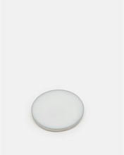 Load image into Gallery viewer, A minimalist, round, solid perfume pan with a subtle grey edge, photographed on a seamless light grey background.
