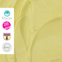 Load image into Gallery viewer, Close-up of yellow cream with Blue Beauty Awards, L'Occitane Healthy Winner, and Sustainability Award logos on the left.
