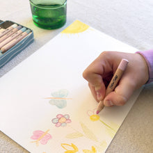 Load image into Gallery viewer, Hand drawing flowers on a piece of paper with colored pencils and a glass of water.

