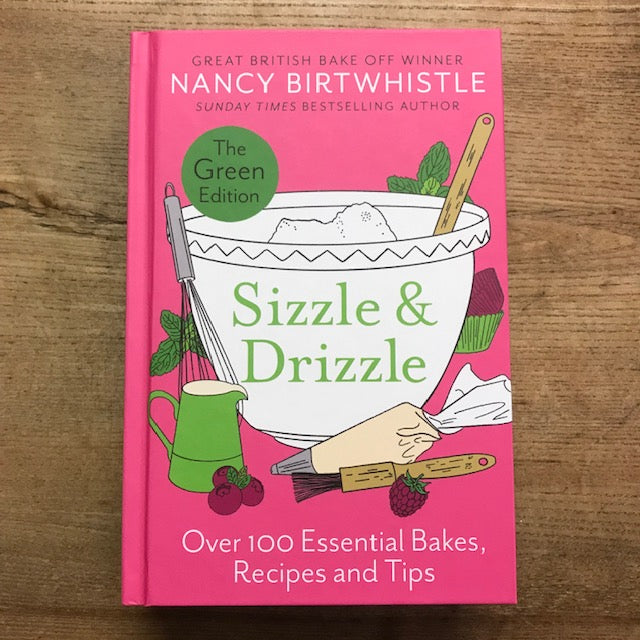 Book titled 'Sizzle & Drizzle' by Nancy Birtwhistle on a wooden surface