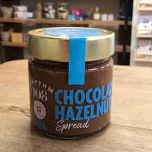 Load image into Gallery viewer, Jar of Rhythm 108 Chocolate Hazelnut Spread on a wooden surface with a blurred background
