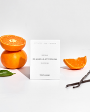 Load image into Gallery viewer, Orange slices, vanilla pod, and a card with product details on a light gray background
