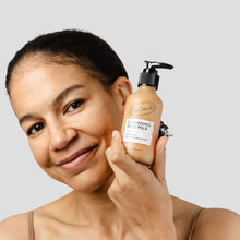 Load image into Gallery viewer, Woman holding a bottle of 'Cleansing Face Milk' against a neutral background
