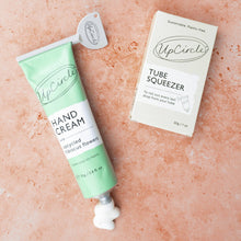Load image into Gallery viewer, UpCircle hand cream tube and packaging on a pink background
